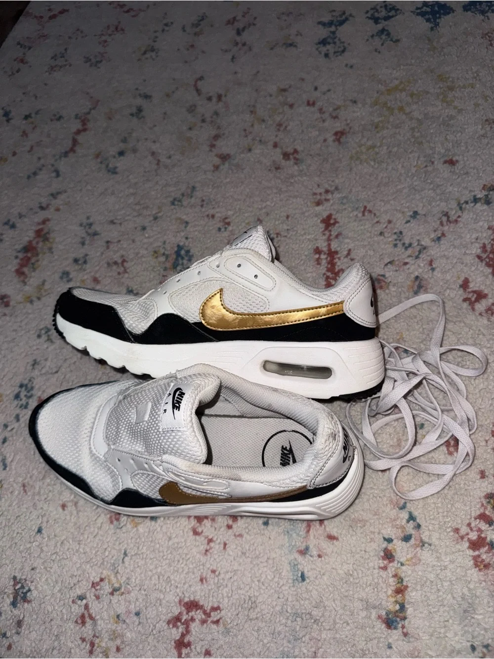 Nike White Sneakers with Black Trim and Gold Swoosh